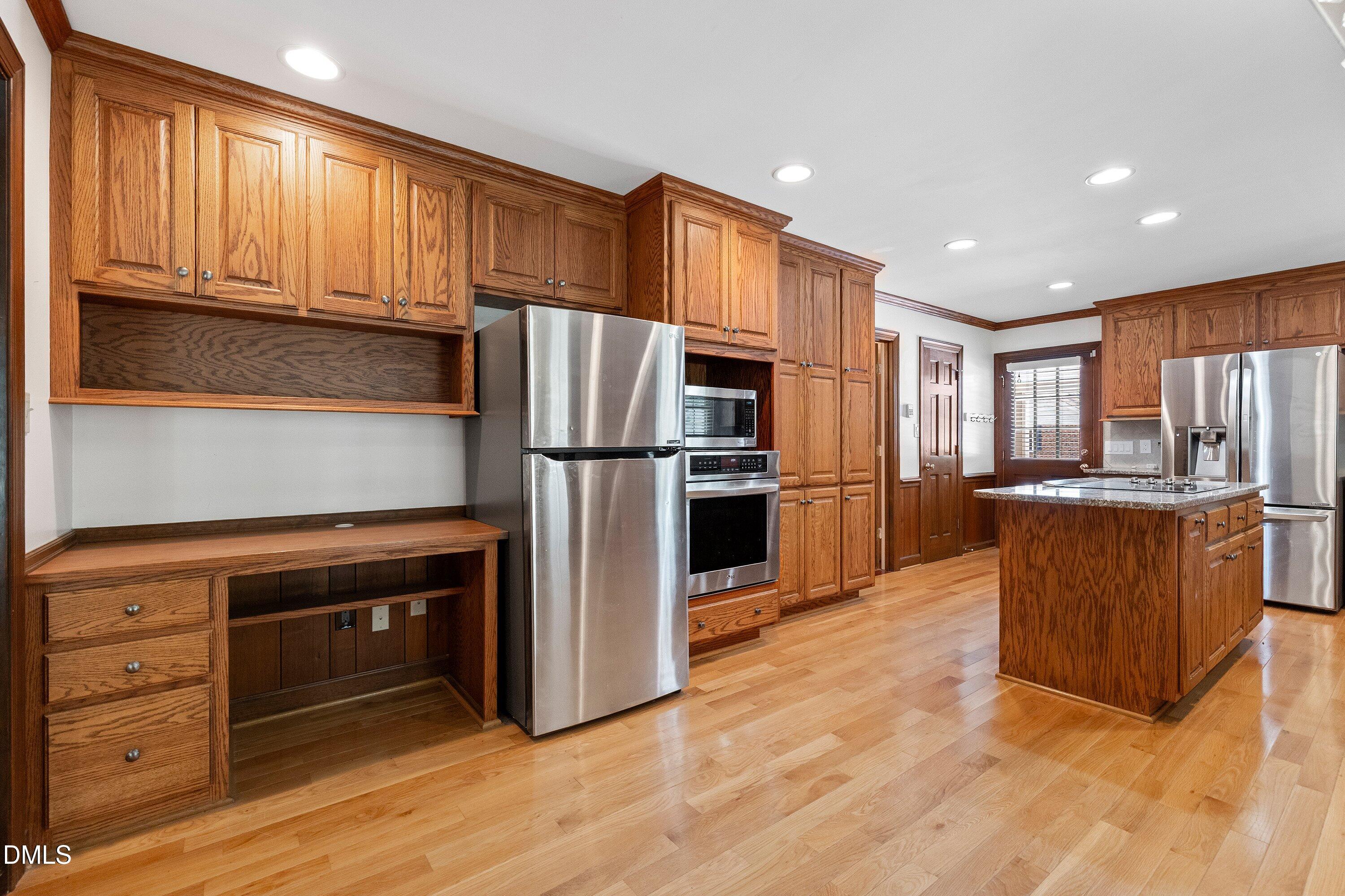 8133 Holly Forest Road Wake Forest, NC 27587 - Photo 12 of 50 a kitchen with stainless steel appliances granite countertop a refrigerator cabinets and wooden floor