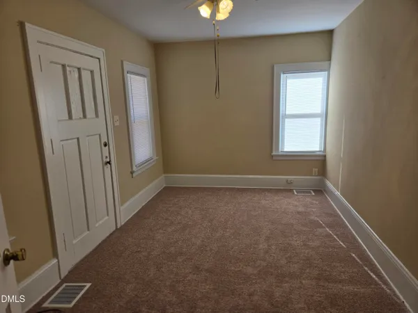 an empty room with windows and closet
