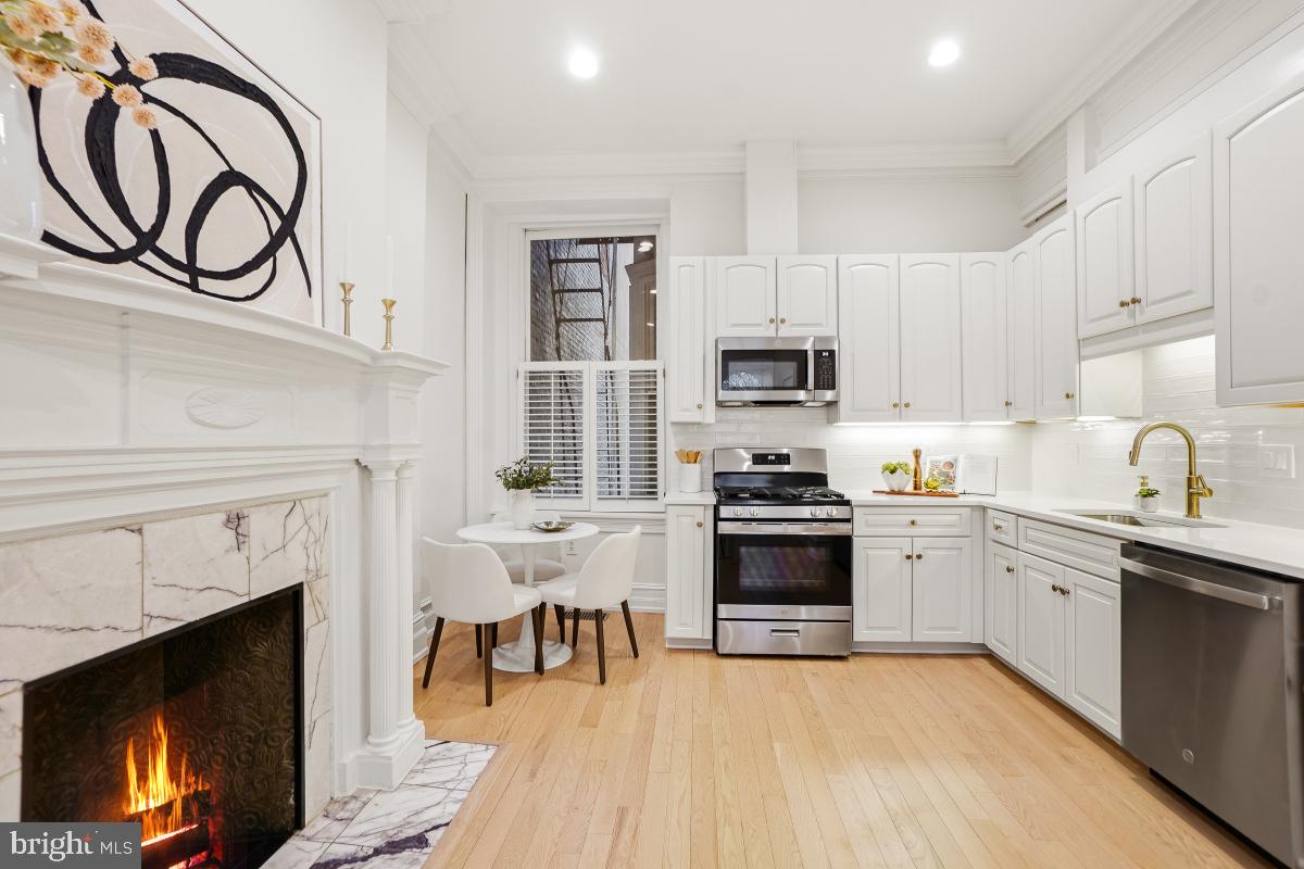 1706 16th Street Northwest, Unit 1 Washington, DC 20009 - Photo 17 of 55 a kitchen with stainless steel appliances granite countertop a stove top oven a sink dishwasher and a fireplace with wooden floor