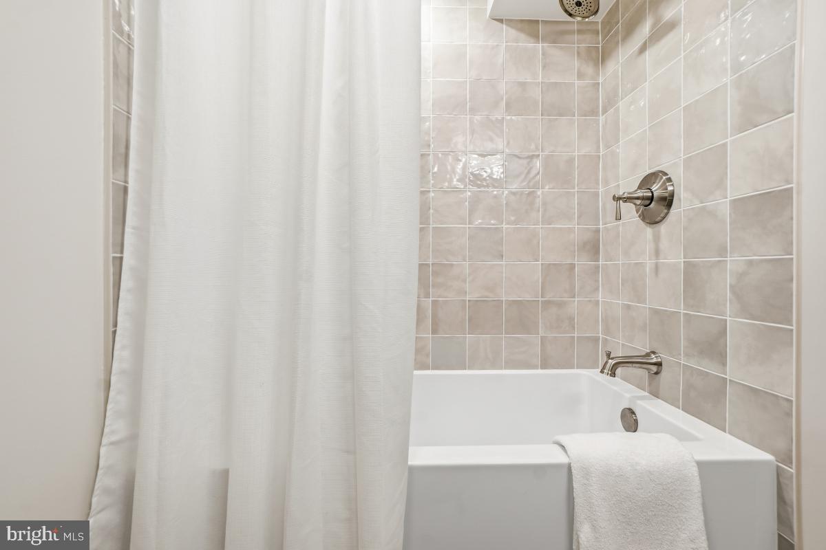 1706 16th Street Northwest, Unit 1 Washington, DC 20009 - Photo 31 of 55 a bathroom with a white bath tub and a shower curtain
