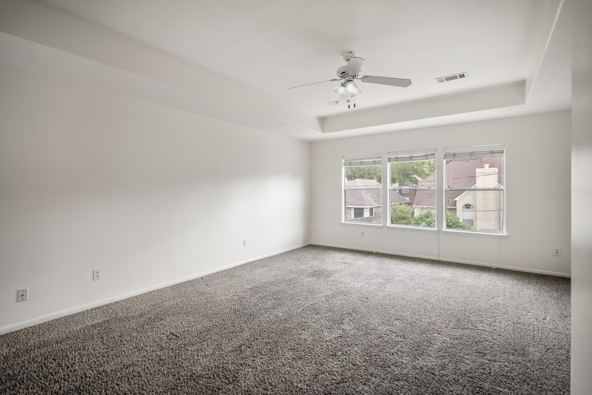 19106 South Rim Trail Spring, TX 77388 - Photo 28 of 50 This view gives the upstairs game room its full sense of scale, with a long open wall, tray ceiling detail, and three windows bringing in soft natural light. The space sits apart from the downstairs living room, giving the home another place to gather, spread out, or keep everyday activity upstairs. With the secondary bedrooms nearby, this level feels practical and flexible without losing the open connection back to the foyer.