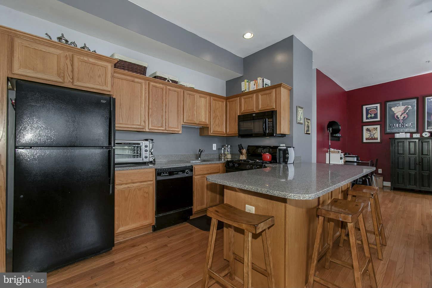 1 18th Street Southeast, Unit 301 Washington, DC 20003 - Photo 6 of 19 a kitchen with stainless steel appliances granite countertop a refrigerator a stove a sink and a microwave with wooden floor