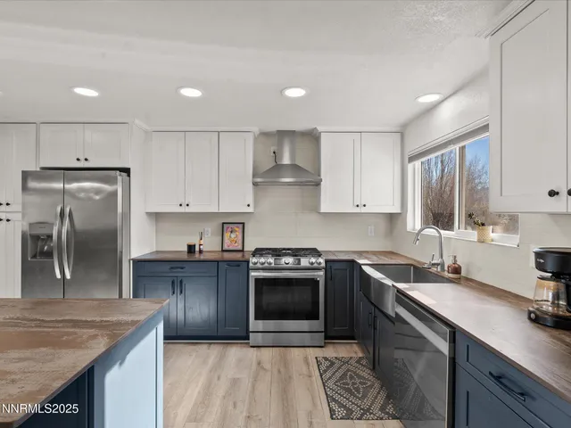 a kitchen with granite countertop kitchen island stainless steel appliances a sink stove and refrigerator