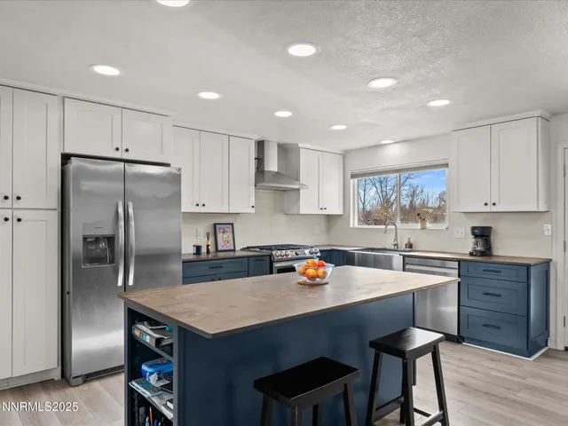 a kitchen with a sink a refrigerator and wooden cabinets