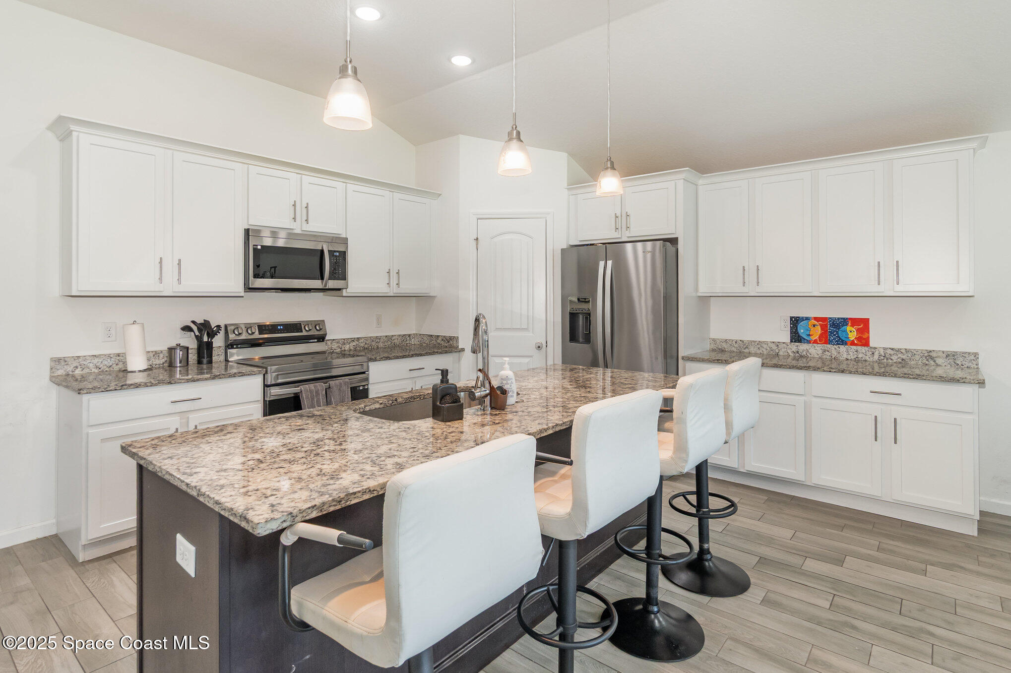 1534 Pine Street Orlando, FL 32824 - Photo 7 of 28 a kitchen with kitchen island granite countertop a table chairs microwave and refrigerator