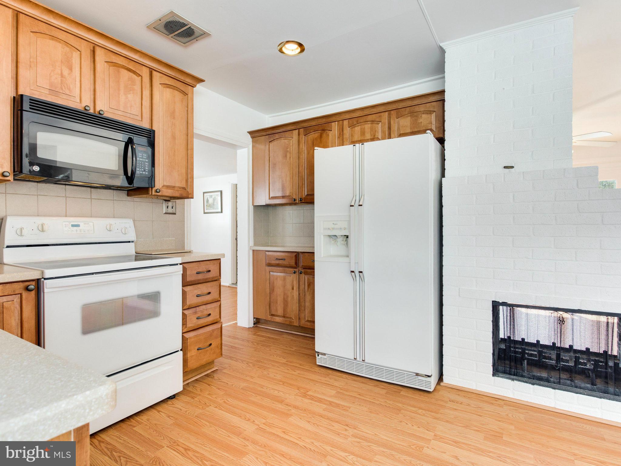 7315 Inzer Street Springfield, VA 22151 - Photo 6 of 23 a kitchen with stainless steel appliances white cabinets and wooden floor