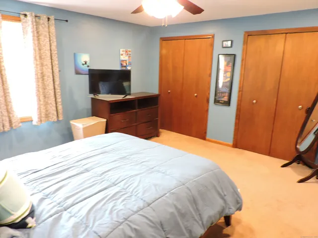 a bedroom with a bed and a flat tv screen next to a window