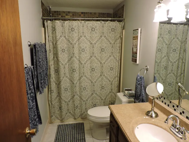 a bathroom with a sink a toilet and shower curtain