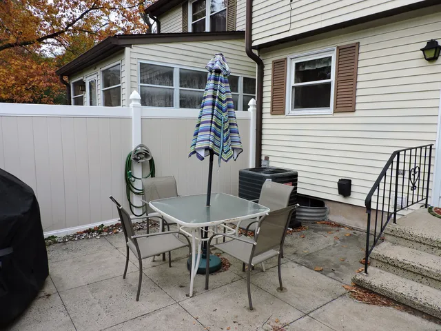 a view of a dinning table and chairs in the back yard of the house