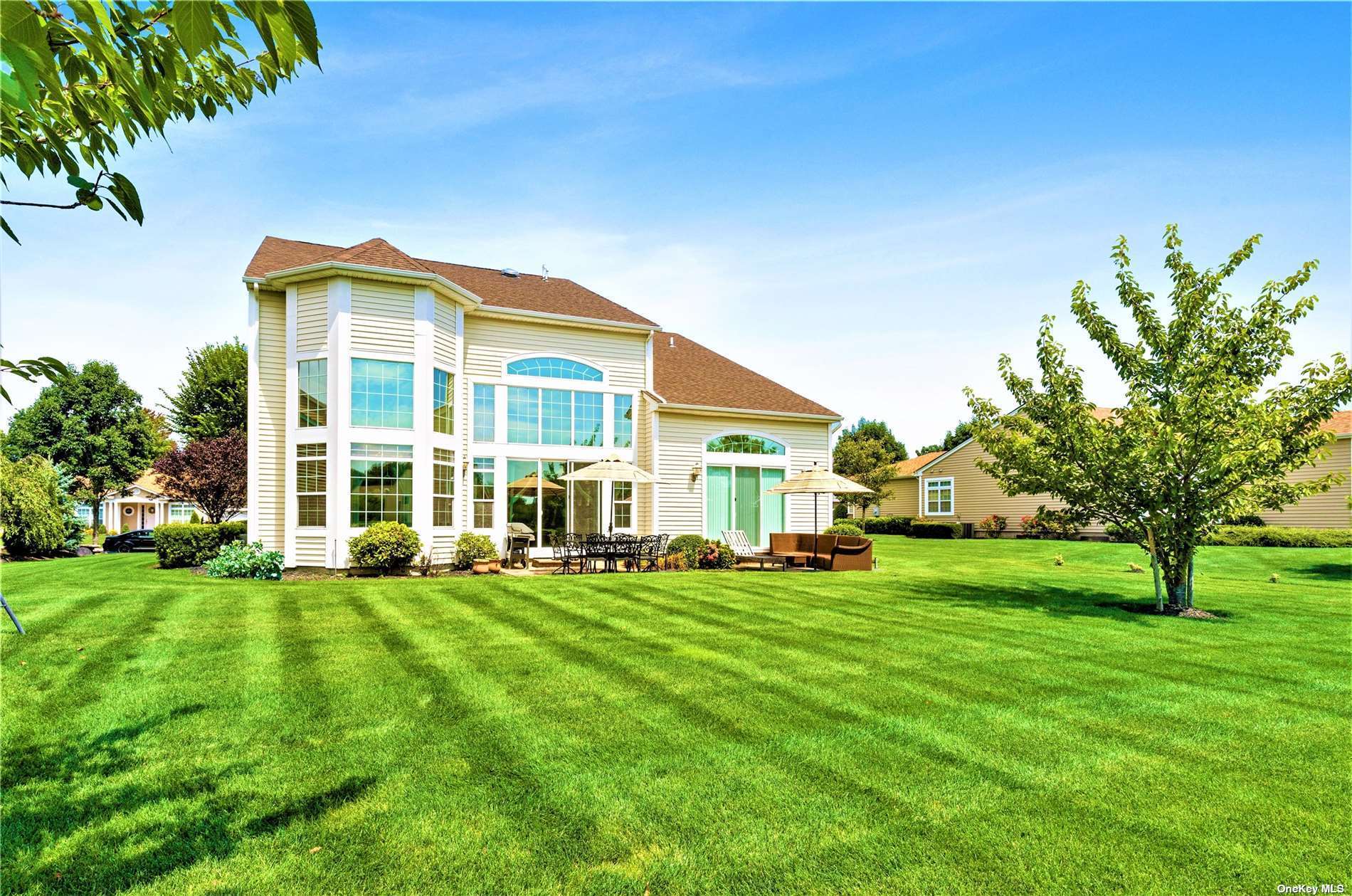 a view of a building with a big yard and large trees