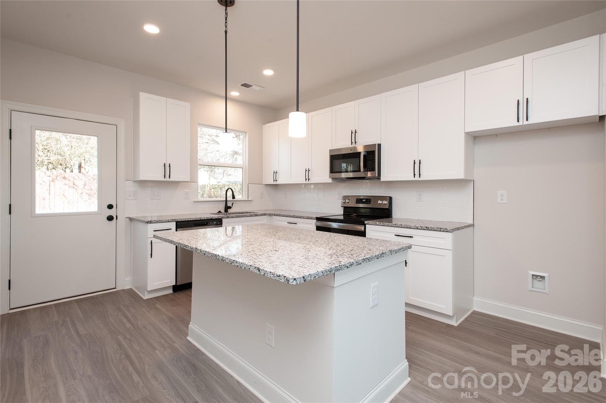 0 Lowesville Meadows Road Stanley, NC 28164 - Photo 13 of 25 a kitchen with stainless steel appliances granite countertop a sink a stove a microwave a refrigerator a sink and dishwasher with wooden floor