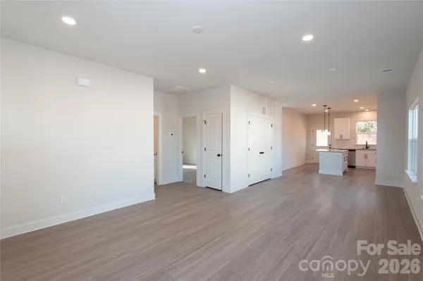 a view of a big room with wooden floor and windows