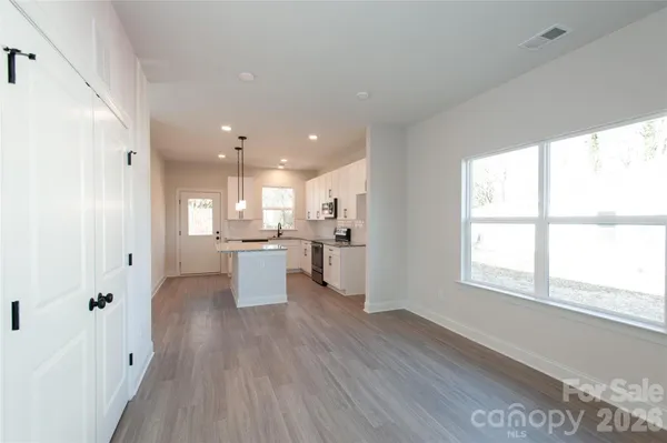 a open kitchen with white cabinets and a refrigerator