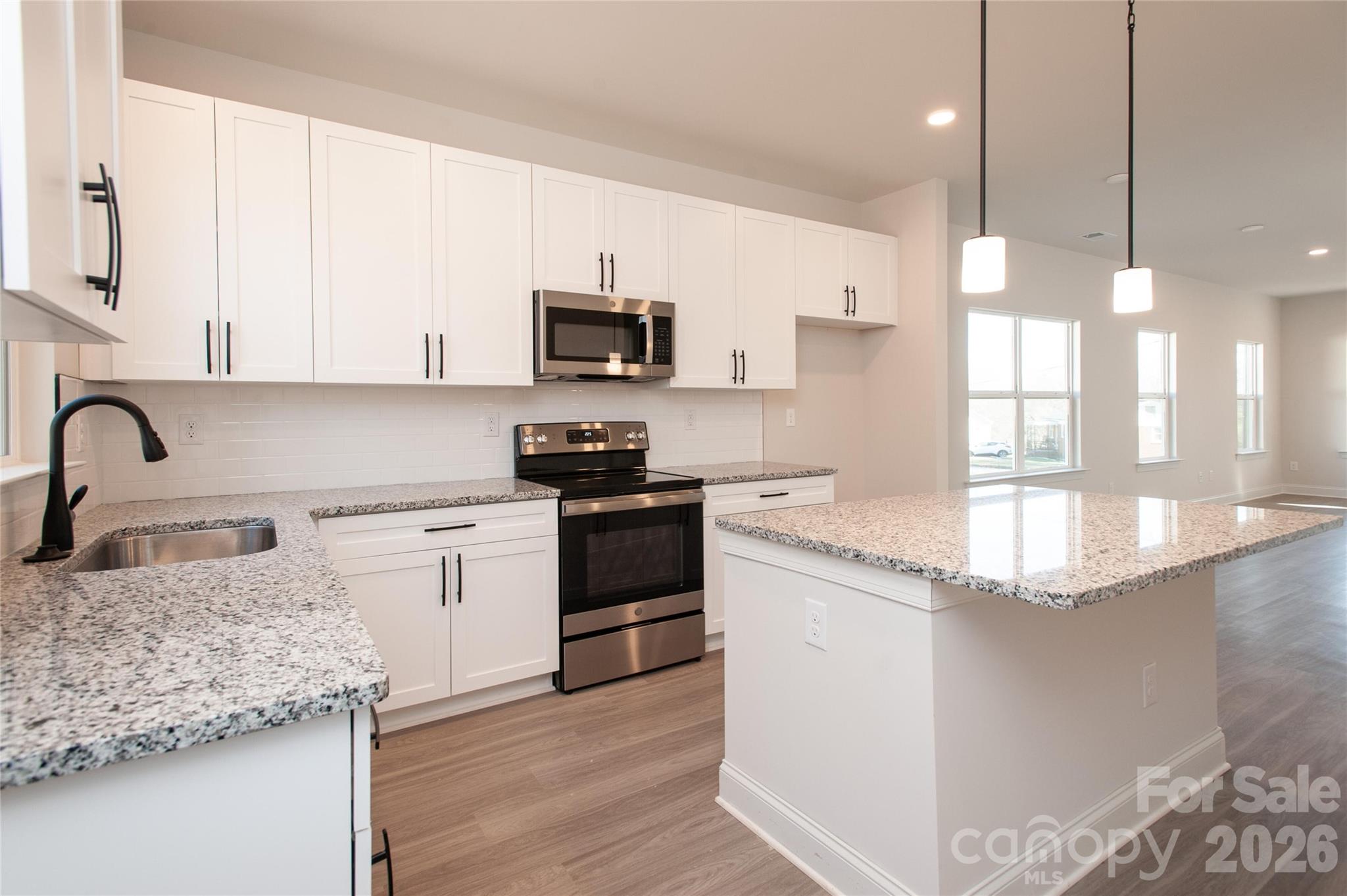 0 Lowesville Meadows Road Stanley, NC 28164 - Photo 10 of 25 a kitchen with stainless steel appliances granite countertop a sink stove and white cabinets