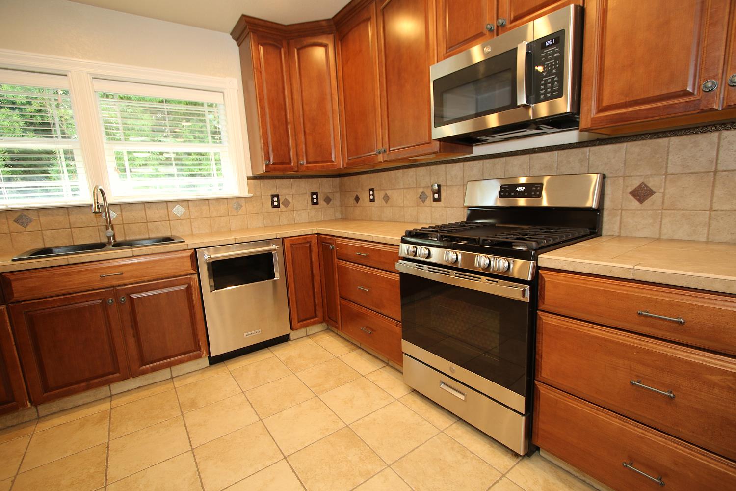 526 Melrose Street Modesto, CA 95354 - Photo 11 of 27 a kitchen with stainless steel appliances granite countertop a stove a sink and a microwave