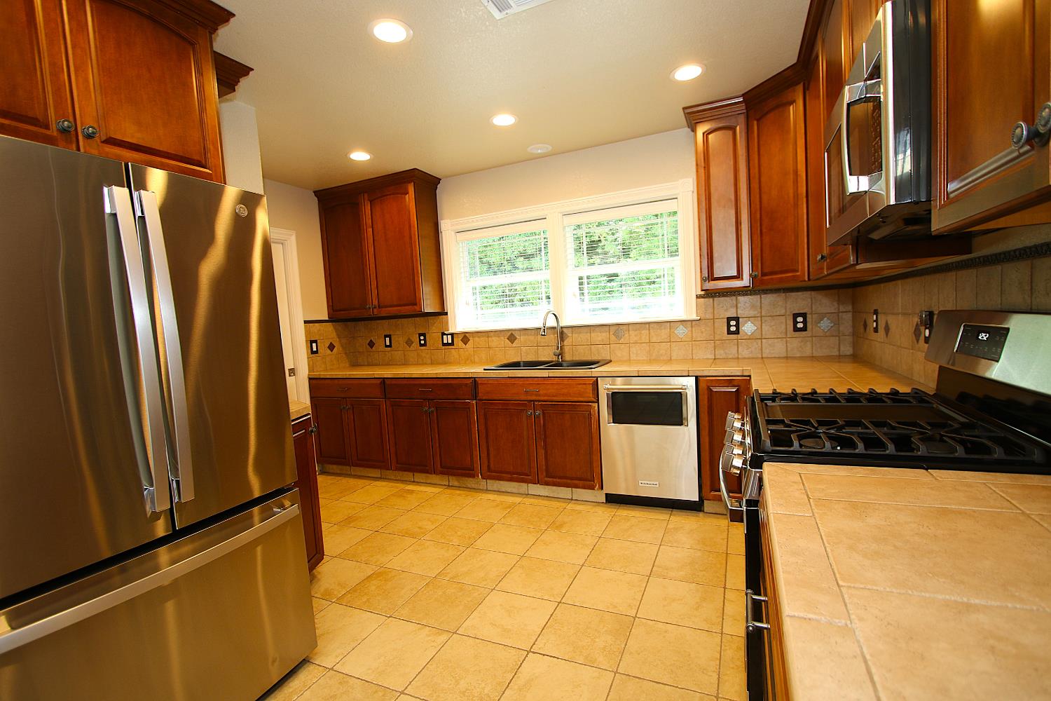 526 Melrose Street Modesto, CA 95354 - Photo 12 of 27 a kitchen with stainless steel appliances granite countertop a stove a sink and a refrigerator
