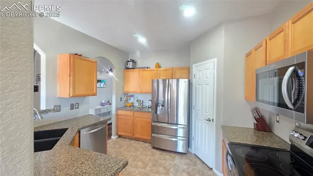 a kitchen with stainless steel appliances granite countertop a refrigerator sink and stove