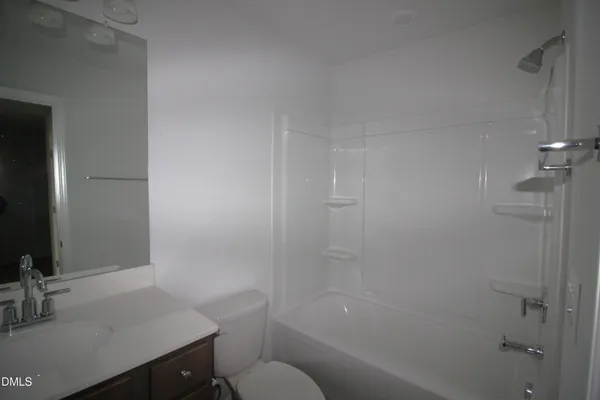 a bathroom with a sink toilet vanity and shower