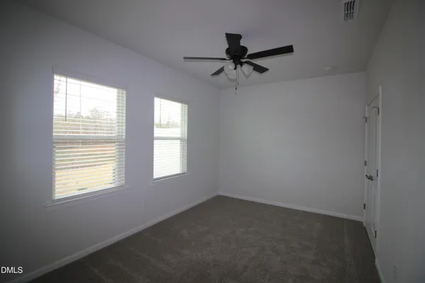 a view of a livingroom with a ceiling fan and window