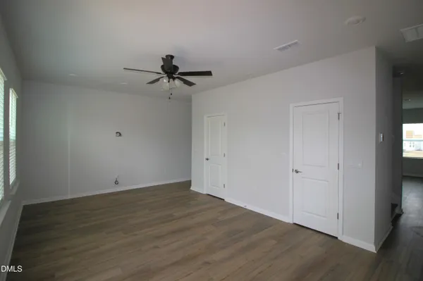a view of a room with wooden floor and a ceiling fan