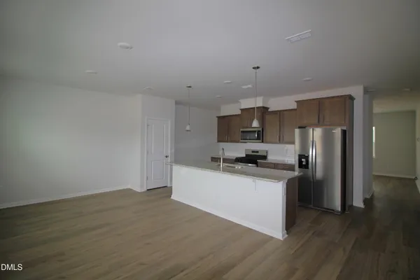 a kitchen with stainless steel appliances a refrigerator and a stove top oven