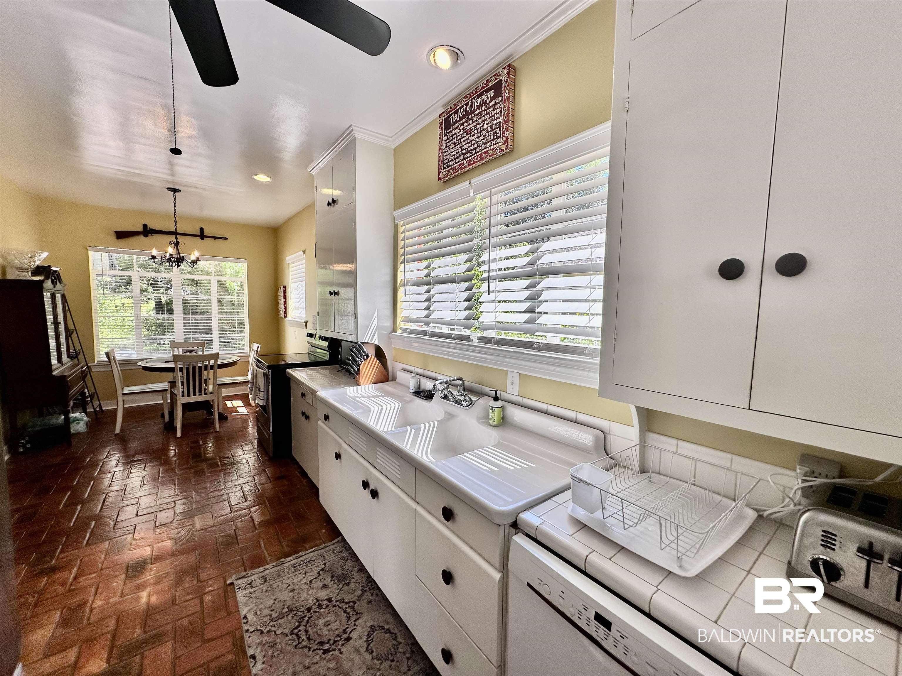 260 Siena Vista Street Mobile, AL 36607 - Photo 21 of 41 Kitchen featuring stainless steel electric stove, tile countertops, brick flooring, white cabinets, and a ceiling fan