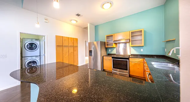 a kitchen with stainless steel appliances granite countertop a refrigerator and a stove top oven