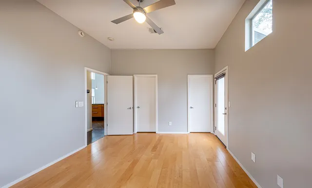 a view of an empty room with a window and wooden floor