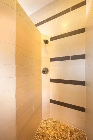 a view of a hallway with wooden floor and a bathroom