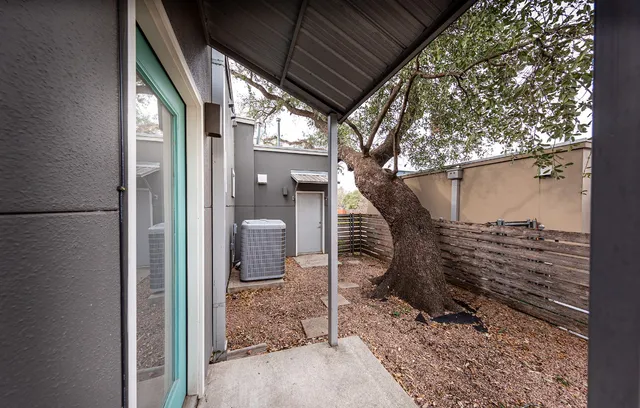 a view of a patio with a table and chairs and wooden fence