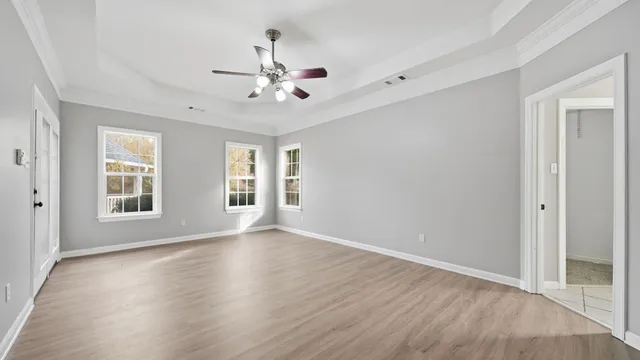 a view of an empty room with a window and wooden floor