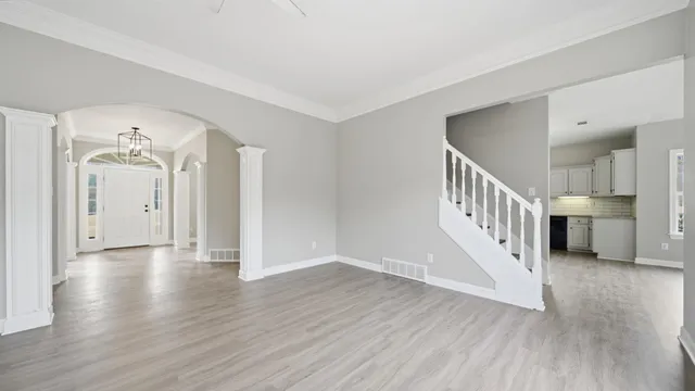 a view of a hallway with wooden floor and stairs