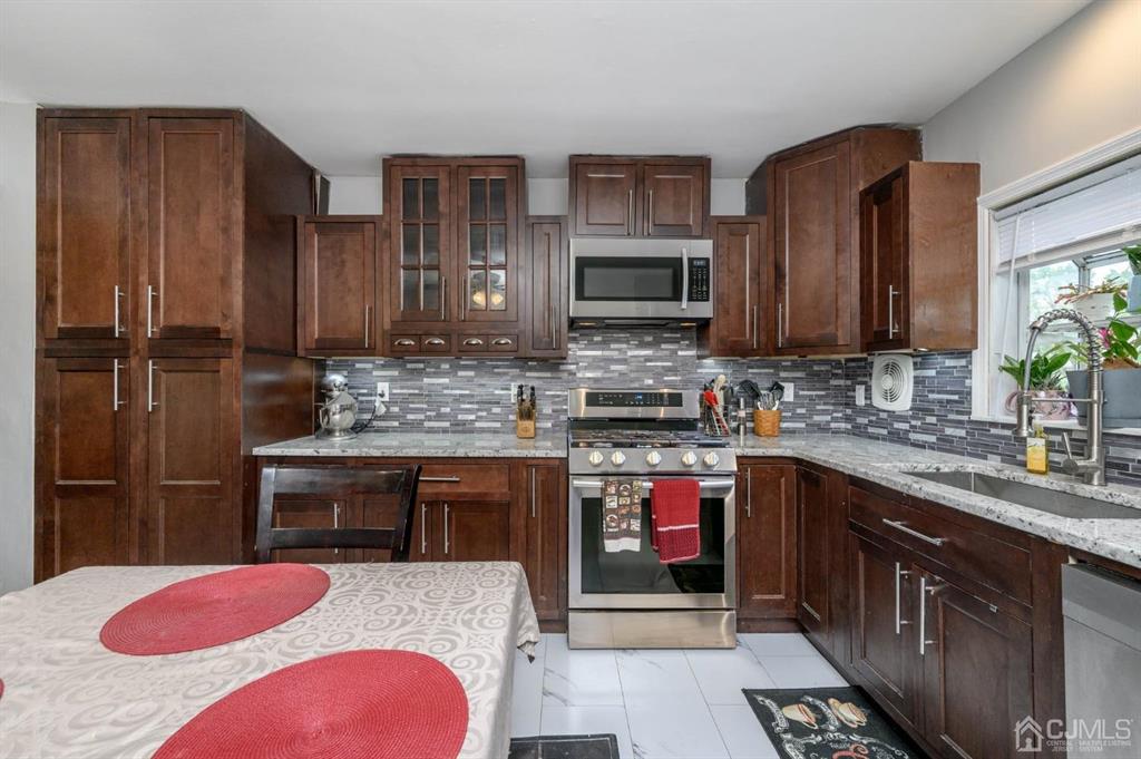 22 Vista Road Hamilton, NJ 08690 - Photo 9 of 38 a kitchen with stainless steel appliances kitchen island granite countertop a sink stove and refrigerator