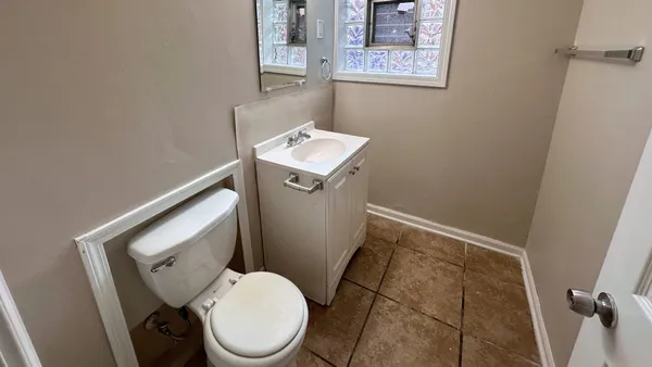 a white toilet sitting next to a small sink