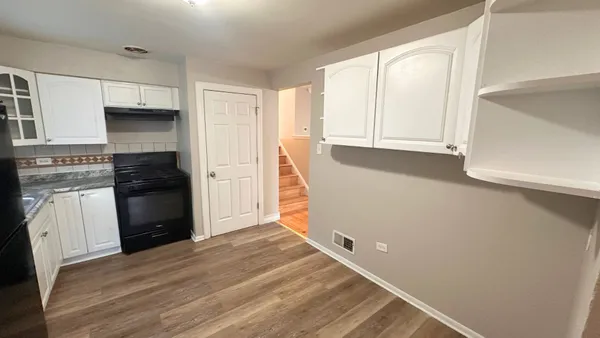 a view of kitchen with wooden floor and electronic appliances