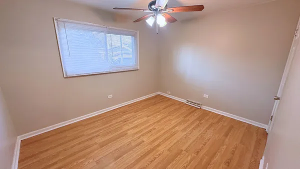 an empty room with a window and a ceiling fan
