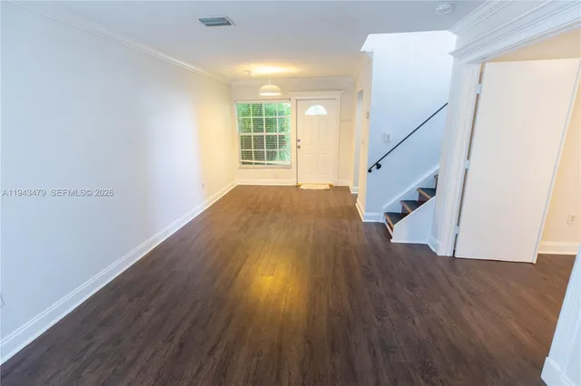 a view of an empty room with wooden floor