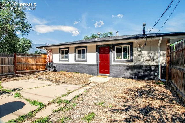 a view of a house with wooden walls and a small yard
