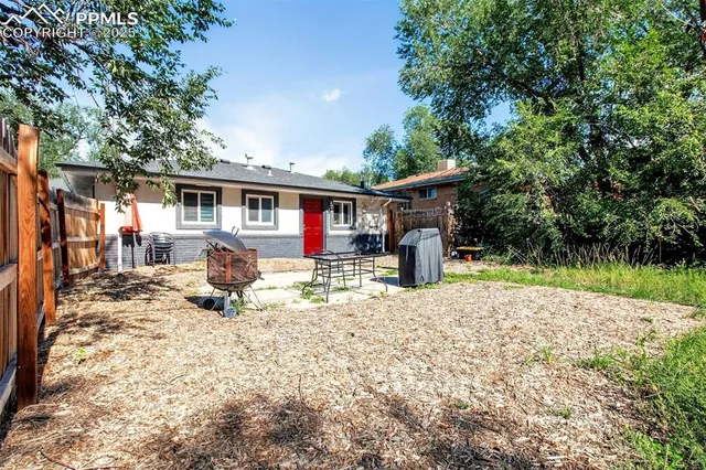 a front view of house with yard and trees in the background