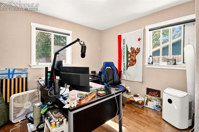 a work room with furniture a rug toys and windows