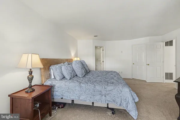 a bedroom with a bed and a lamp