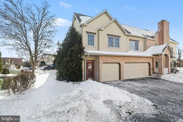a view of a house with a yard covered in snow