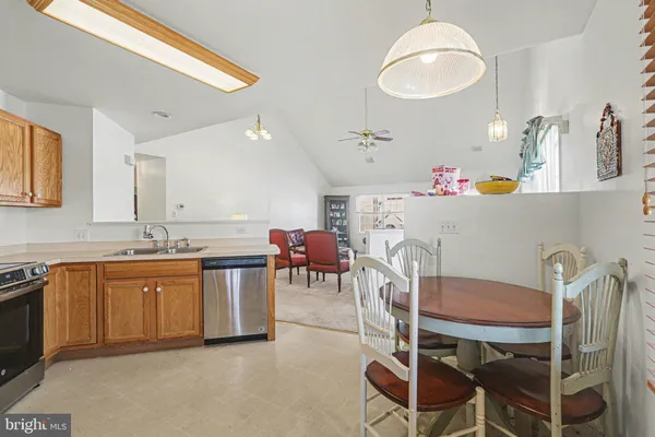 a kitchen with a dining table chairs sink and stove