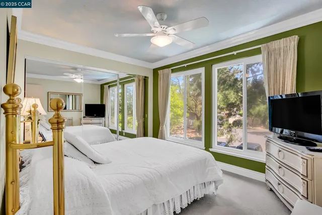 a bedroom with a bed and a flat tv screen on dresser