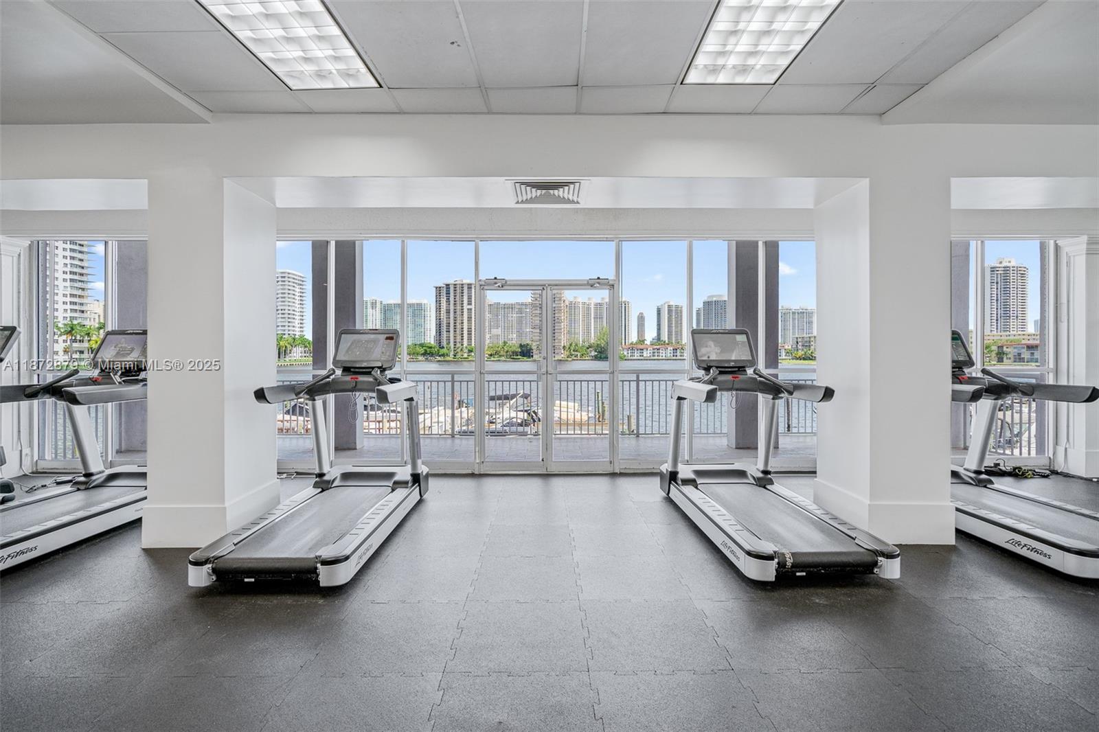 18071 Biscayne Boulevard, Unit PH04 & PH03 Aventura, FL 33160 - Photo 17 of 26 a living room with gym equipment