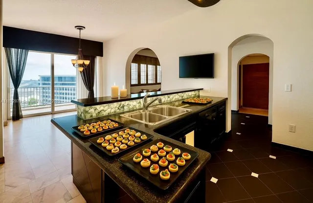 a kitchen that has a stove and a flat screen tv