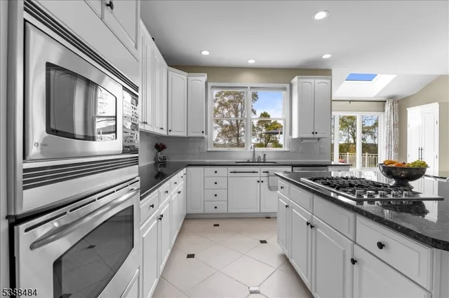 a kitchen with granite countertop white cabinets and white appliances