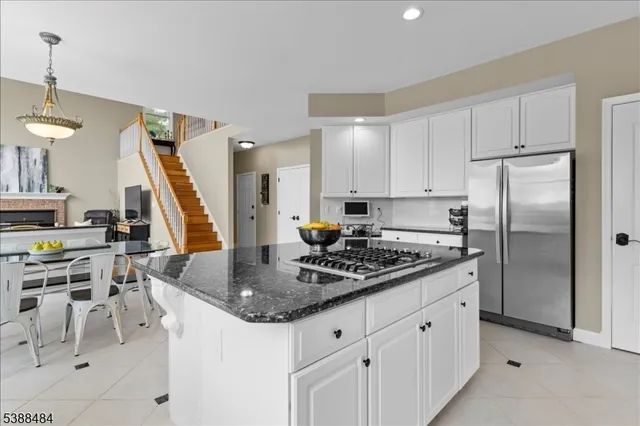 a kitchen with stainless steel appliances granite countertop a sink a stove and a refrigerator
