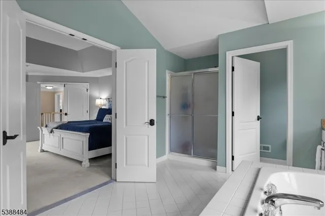 a spacious bedroom with a bed and a mirror