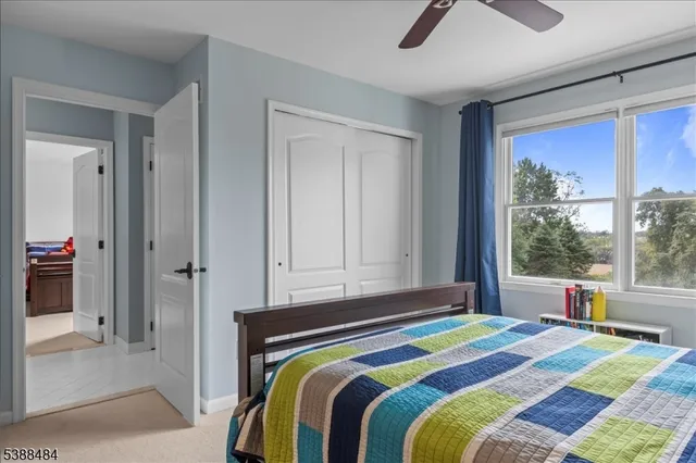 a bedroom with a bed a chandelier and a window